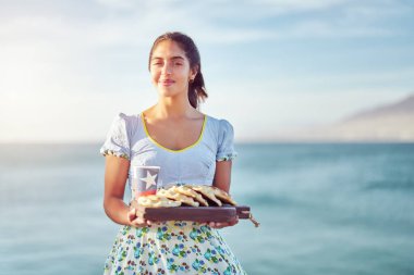 Geleneksel kostüm giymiş Şilili bir kadının portresi elinde Empanadas ve üzerinde Şili bayrağı olan geri dönüşümlü bir bardak, tatil ve Bağımsızlık Günü konsepti. 