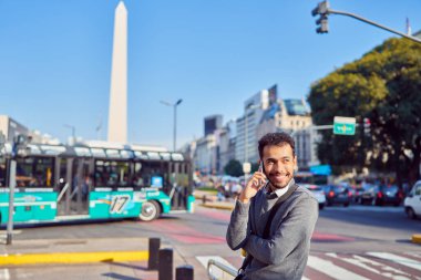 Latin Amerikalı adam Buenos Aires sokaklarında telefonla konuşuyor.