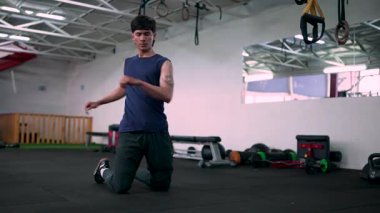 Fizikçi modern spor salonunda hareket ve bacak esnetme alıştırması yapıyor.