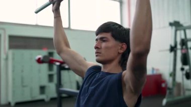 Erkek fitness meraklısı, sırt kaslarını aşağı çekme egzersiziyle güçlendirir.