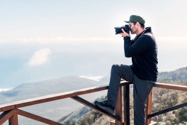 Elinde kamera olan olgun bir adam Pasifik Okyanusu 'nun fotoğraflarını çekiyor. 