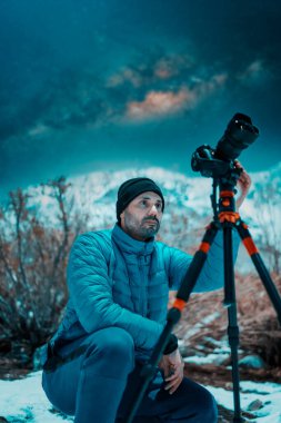 Geceleri kar altında fotoğrafçı karlı dağda yıldızların ve Samanyolu 'nun fotoğraflarını çekiyor.