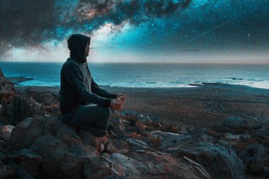 Tepenin tepesinde bir insan gece Samanyolu 'yla meditasyon yapıyor ya da dua ediyor.