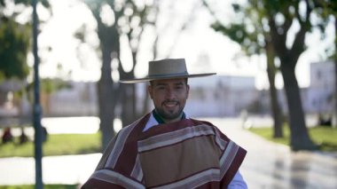 Şilili Huaso kostümlü bir gencin portresi meydanda poz veriyor, Şili Patrias kutlamaları. 