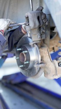 Mekanik bir atölyede tamircinin ellerinin fren diskini değiştirmesini kapat