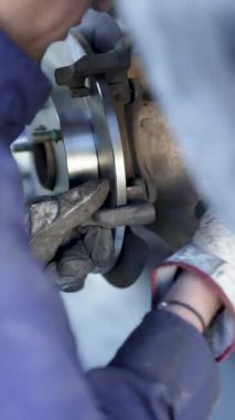 Mekanik bir atölyede tamircinin ellerinin fren diskini değiştirmesini kapat