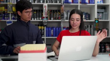 Oto yedek parça deposundaki yöneticiye yeni hava filtresi gösteriliyor