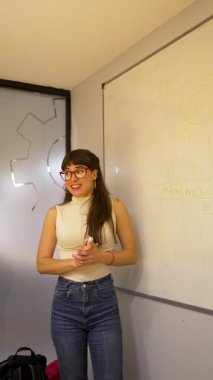 Beyaz tahta üzerine beyaz tahta kalemle yazı yazan genç beyaz iş kadını ya da öğretmen.