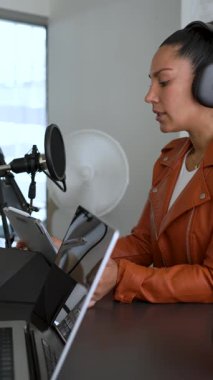Kadın radyo sunucusu stüdyoda ses podcast 'i kaydediyor