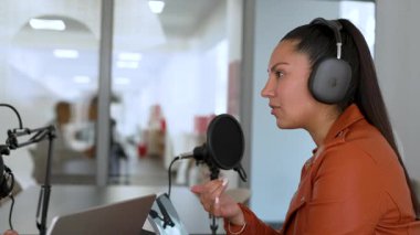 İspanyol kadın stüdyoda ses yayını yapıyor. İçerik oluşturucu çalışıyor