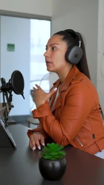 Bayan radyo sunucusu stüdyodaki konuğuyla konuşan ses yayını yapıyor.