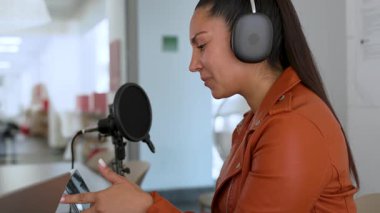 İspanyol kadın stüdyoda ses yayını yapıyor. İçerik oluşturucu çalışıyor