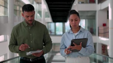 İki yönetici iş projesini tartışıyor ve not defteri ve tablet bilgisayar kullanarak not alıyor 