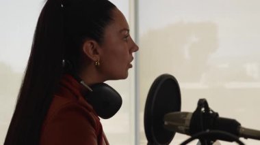 İspanyol kadın stüdyoda ses yayını yapıyor. İçerik oluşturucu çalışıyor