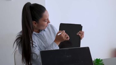 İki iş arkadaşı bir projeyi tartışıyor. Kadın tabletindeki verileri bir erkeğe gösteriyor. 