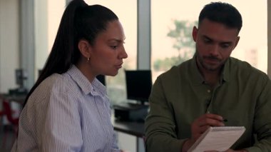 İki yönetici iş projesini tartışırken ofiste birlikte oturuyorlar. 