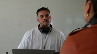 İki radyo sunucusu bir stüdyoda canlı yayın sırasında sohbet ediyorlar.. 