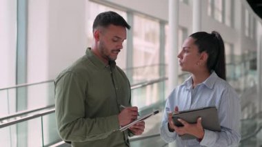 İki yönetici iş projesini tartışıyor ofiste duruyor ve notlar alıyor.