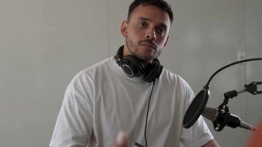 İki radyo sunucusu bir stüdyoda canlı yayın sırasında sohbet ediyorlar.. 