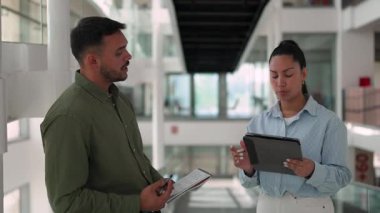 İki yönetici iş projesini tartışıyor ve not defteri ve tablet bilgisayar kullanarak not alıyor 