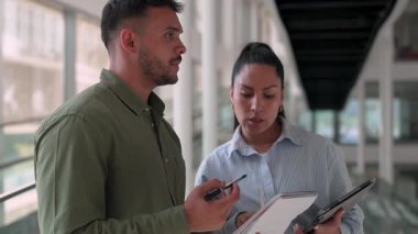 İki yönetici iş projesini tartışıyor ofiste duruyor ve notlar alıyor.