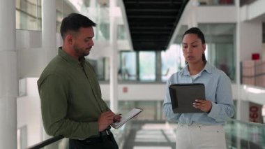 İki yönetici iş projesini tartışıyor ve not defteri ve tablet bilgisayar kullanarak not alıyor 