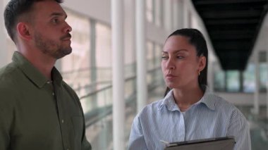 İki yönetici iş projesini tartışıyor ofiste duruyor ve notlar alıyor.