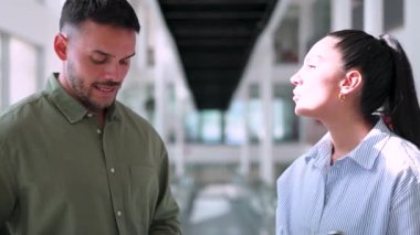 İki yönetici iş projesini tartışıyor ofiste birlikte yürüyor ve notlar alıyorlar.