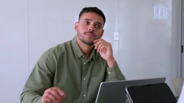 Genç endişeli adam ve bayan meslektaşı ofiste birlikte çalışıyorlar.