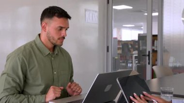 Genç endişeli adam ve bayan meslektaşı ofiste birlikte çalışıyorlar.