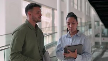 İki yönetici iş projesini tartışıyor ofiste duruyor ve notlar alıyor.