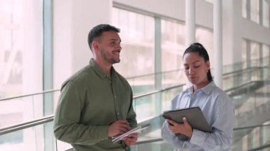 İki yönetici iş projesini tartışıyor ofiste duruyor ve notlar alıyor.