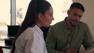 İki yönetici iş projesini tartışırken ofiste birlikte oturuyorlar. 