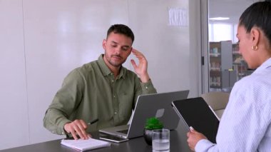 Genç endişeli adam ve bayan meslektaşı ofiste birlikte çalışıyorlar.