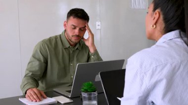 Genç adam ve bayan meslektaşı ofiste birlikte çalışıyorlar.