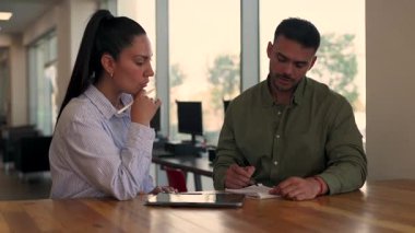 İki yönetici iş projesini tartışırken ofiste birlikte oturuyorlar. 