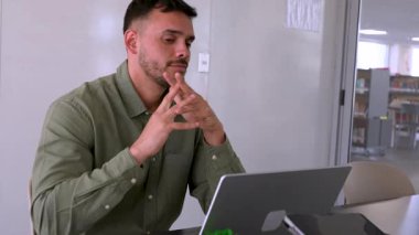 Ofiste çalışan endişeli ve yorgun genç bir adam.