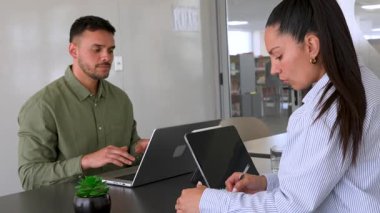 Genç endişeli adam ve bayan meslektaşı ofiste birlikte çalışıyorlar.