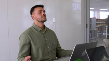 Genç endişeli adam ve bayan meslektaşı ofiste birlikte çalışıyorlar.