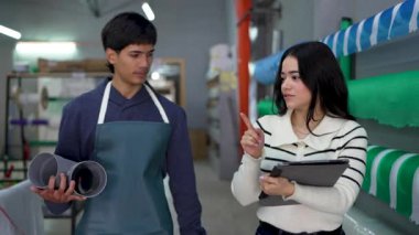 Genç bir hırdavatçı, dijital tablet kullanan bir müşteriye farklı borular gösteriyor.