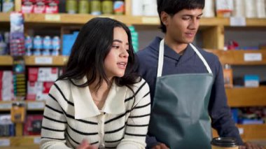 İki genç esnaf mola veriyor, kahve içiyor ve akıllı telefonları kontrol ediyorlar.