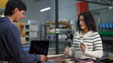 Genç Latin kadın hırdavatçıdan mal alıyor.