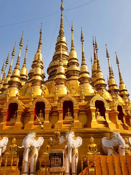 stock image Golden pagodas with buddha statues and elephants at the buddhist temple Wat Phra That Suthon Mongkhon Khiri in Phrae, northern Thailand