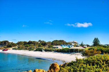 Hopetoun 'daki sahil, Batı Avustralya' nın güney sahilinde ücra bir kasaba, kristal berrak su, kum tepeleri, kıyı bitkileri ve sahilde bir araba.