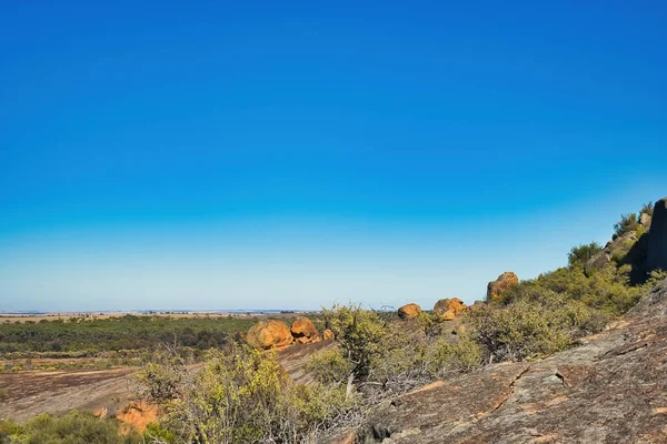 stock image Eroded rocks and boulders with stunted outback vegetation in  Sandford Rocks Nature Reserve, a granite outcrop near Westonia, Western Australia.