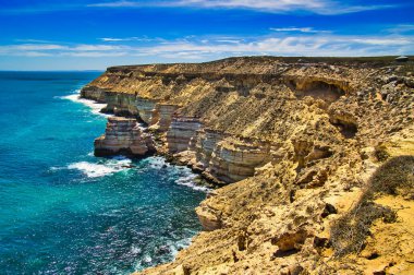Batı Avustralya 'nın orta batı kıyısı boyunca uzanan Kalbarri Ulusal Parkı' nın katmanlı kumtaşı kayalıklarıyla vahşi sahil.
