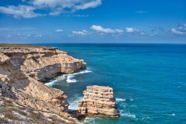 Batı Avustralya 'daki Kalbarri Ulusal Parkı' nın kıyı kayalıklarında Tamala kireçtaşıyla kaplı katmanlı Tumblagooda kumtaşı..
