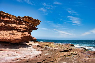 Batı Avustralya 'daki Kalbarri Ulusal Parkı kıyısında kaya havuzları ile ağır şekilde aşınmış kırmızı-kahverengi kumtaşı kayalıkları ve kaya platoları.