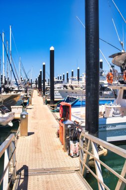 Batı Avustralya 'nın Mercan Sahili' ndeki Exmouth marinasında uzun, siyah demirleme yerleri olan Jetty.