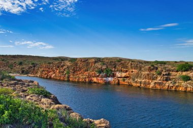 Batı Avustralya 'daki Cape Range Ulusal Parkı' ndaki Yardie Deresi geçidi, kırmızı kireçtaşı kayaları ve bodur taşra bitki örtüsüyle.